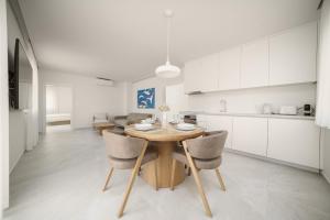 a kitchen and dining room with a wooden table and chairs at Apartments Bianca Vodice in Vodice