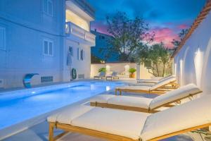 a villa with a swimming pool with lounge chairs at Apartments Bianca Vodice in Vodice