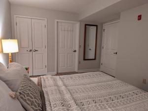 a bedroom with a bed and a lamp and a mirror at Premium New 1bd Sunset balcony 3rd flr in Vernon Township