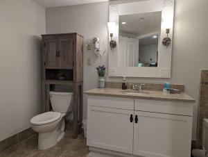 a bathroom with a toilet and a sink and a mirror at Premium New 1bd Sunset balcony 3rd flr in Vernon Township +9 photos