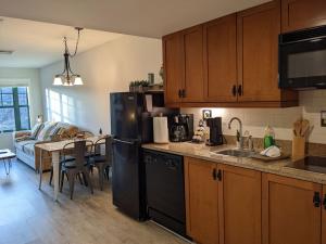 a kitchen with a black refrigerator and a table at Renovated Chic Premium 1 bdrm in Vernon Township