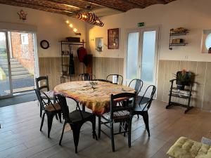 a dining room with a table and chairs at Le CappyToiT - Gîte climatisé in Cappy