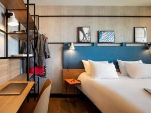 a hotel room with a large bed and a desk at ibis Strasbourg Centre Les Halles in Strasbourg