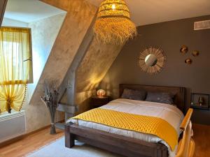 a bedroom with a bed and a chandelier at Chambre proche circuit in Spay