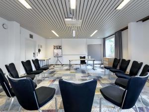 a meeting room with chairs and a table and a podium at Mercure Hotel Köln West in Cologne +163 photos