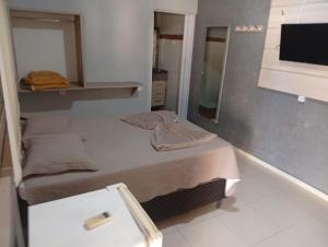 a small bedroom with a bed and a mirror at Restaurante e Hotel Campos in Nova Andradina