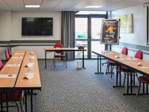 a conference room with tables and chairs and a flat screen tv at ibis Saintes in Saintes +105 photos