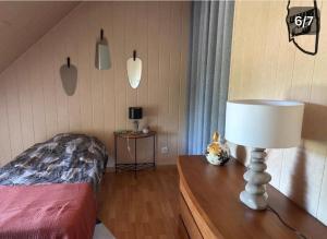 a bedroom with a bed and a lamp on a table at Chambre proche circuit in Spay