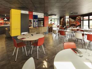 ein Restaurant mit Tischen und Stühlen und einer Cafeteria in der Unterkunft Ibis Évry-Courcouronnes in Courcouronnes