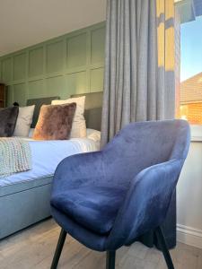 a blue chair in a bedroom with a bed at United Home B&B in Manchester +45 photos