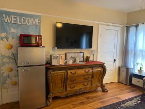a kitchen with a refrigerator and a television on a wall at Suite in Downtown Riverside in Riverside