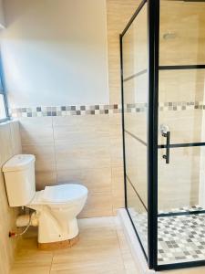 a bathroom with a toilet and a glass shower at Rainow guest house in Burgersfort