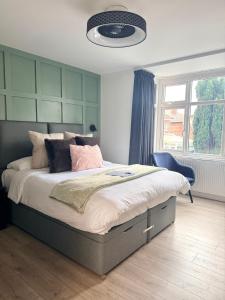 a bedroom with a bed with a green headboard at United Home B&B in Manchester