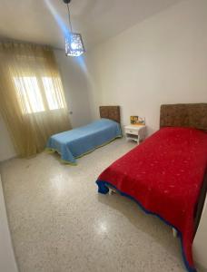 a bedroom with a bed and a red blanket at Superbe appartement emplacement exceptionnel in Tunis