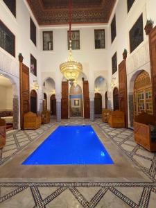 a large room with a large blue swimming pool at Riad Fez Guests in Fez