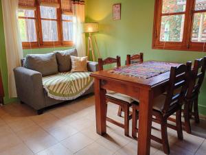 a living room with a table and a couch at Cabañas Rowal Potrerillos in Potrerillos