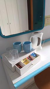 a shelf with three cups and bowls on a table at Villa Petrusa in Stromboli +48 photos