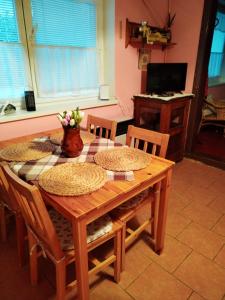 a dining room table and chairs with a table and a television at Ubytování U Trati in Moravská Nová Ves