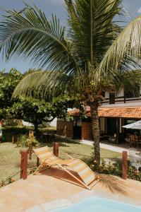 a palm tree and a hammock in front of a resort at Pousada Piratininga in Niterói