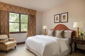 a bedroom with a large white bed and a chair at Hotel Granduca Houston in Houston +24 photos