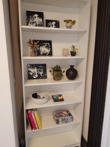 a white book shelf with books and plants at STAY Billund in Vandel