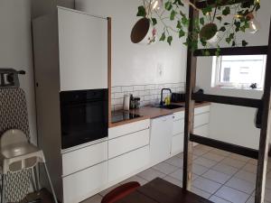 a kitchen with white cabinets and a tree in it at STAY Billund in Vandel