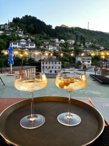 two wine glasses sitting on a table with a view at Alsara Guesthouse in Gjirokastër