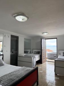 a bedroom with two beds and a view of the ocean at Shiroke Relax Villa in Shirokë