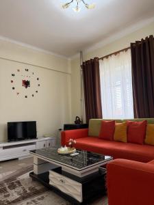 a living room with a red couch and a coffee table at Shiroke Relax Villa in Shirokë