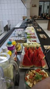 a buffet with many plates of food on a counter at Hotel Recanto do Bosque in Sorriso
