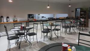 a group of tables and chairs in a restaurant at Hotel Recanto do Bosque in Sorriso