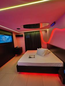 a bedroom with a bed in a room with red lights at Fashion Motel in Limeira