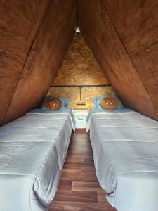 two beds in a room with two donuts on them at Salkantay Star Camp Chaullay in Colcapampa