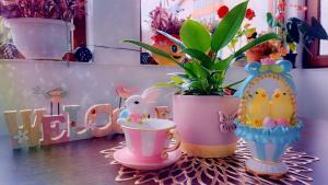 a table with two cups and a potted plant at Little Bear Busteni 3 - Închiriere integrală, cameră de jocuri, parcare privată, potrivită și pentru munca la distanță in Buşteni