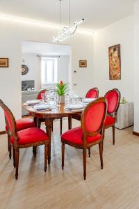 a dining room with a table and red chairs at ARONA STORICO SYC Favoloso 2CAMERE 2BAGNI in Arona