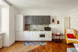 a kitchen with white cabinets and a table and a chair at ARONA STORICO SYC Favoloso 2CAMERE 2BAGNI in Arona +24 photos