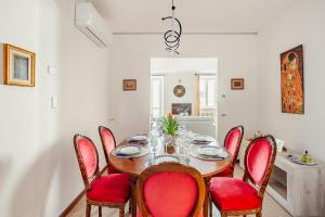 a dining room with a table and red chairs at ARONA STORICO SYC Favoloso 2CAMERE 2BAGNI in Arona