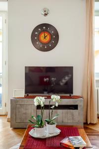 a clock on the wall above a tv in a living room at ARONA STORICO SYC Favoloso 2CAMERE 2BAGNI in Arona