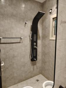a shower in a bathroom with a phone on the wall at ROOM - Alwazirya in Jeddah
