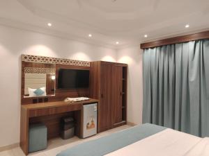 a hotel room with a bed and a television at ROOM - Alwazirya in Jeddah