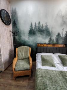 a bedroom with a bed and a chair with a forest mural at W pięknej KAMIENICY in Wałbrzych