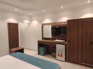 a bedroom with a bed and a mirror and a tv at ROOM - Alwazirya in Jeddah