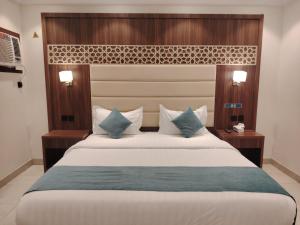 a bedroom with a large white bed with blue pillows at ROOM - Alwazirya in Jeddah