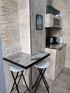 a counter with two stools in a small kitchen at W pięknej KAMIENICY in Wałbrzych