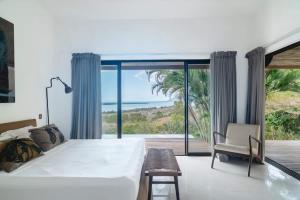 a bedroom with a large bed and a view of the ocean at Villa Baki - Luxe & Ocean View in Le Morne +23 photos
