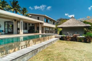 a villa with a swimming pool and a house at Villa Baki - Luxe & Ocean View in Le Morne