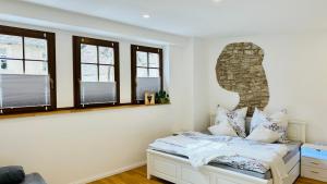 a bedroom with white walls and windows and a bed at Kalkgold Refugium in Kitzingen