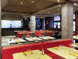 a restaurant with red chairs and tables and a bar at ibis Douala in Douala