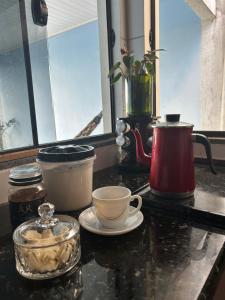 a counter top with coffee pots and cups on it at Casa Takahashi in Ariquemes