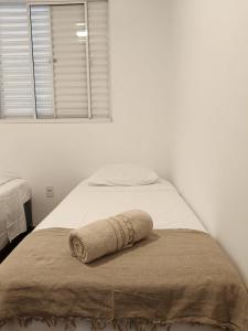 a bed with a towel on it with a window at Lua da Mantiqueira - Staffy House Extrema in Extrema +49 photos
